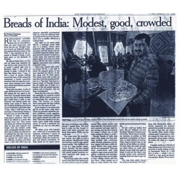 A newspaper article about "Breads of India" features a man holding a large flatbread in a restaurant.