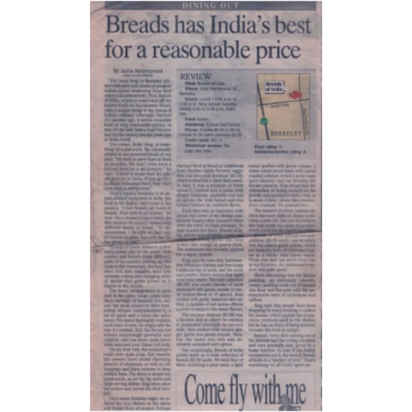 A newspaper clipping with a review of "Breads of India" restaurant, including a map and text.